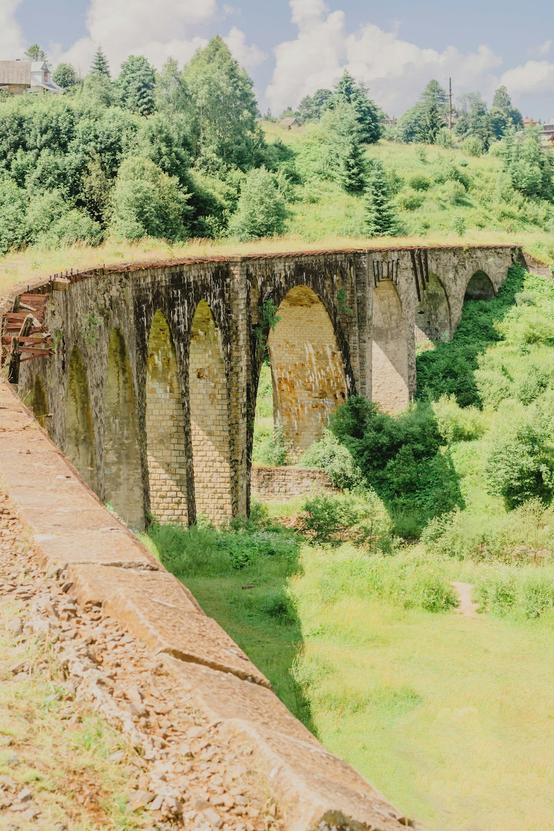 brown concrete bridge over green grass field during daytime