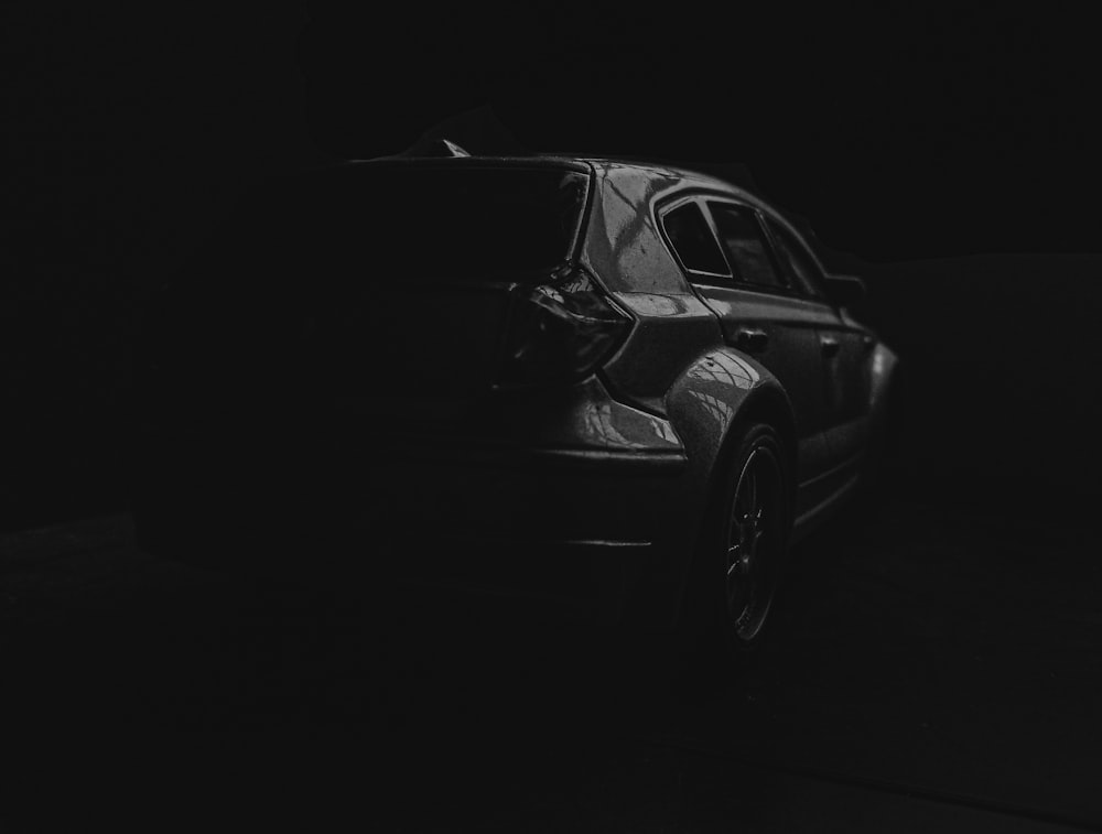 grayscale photo of sedan on black background