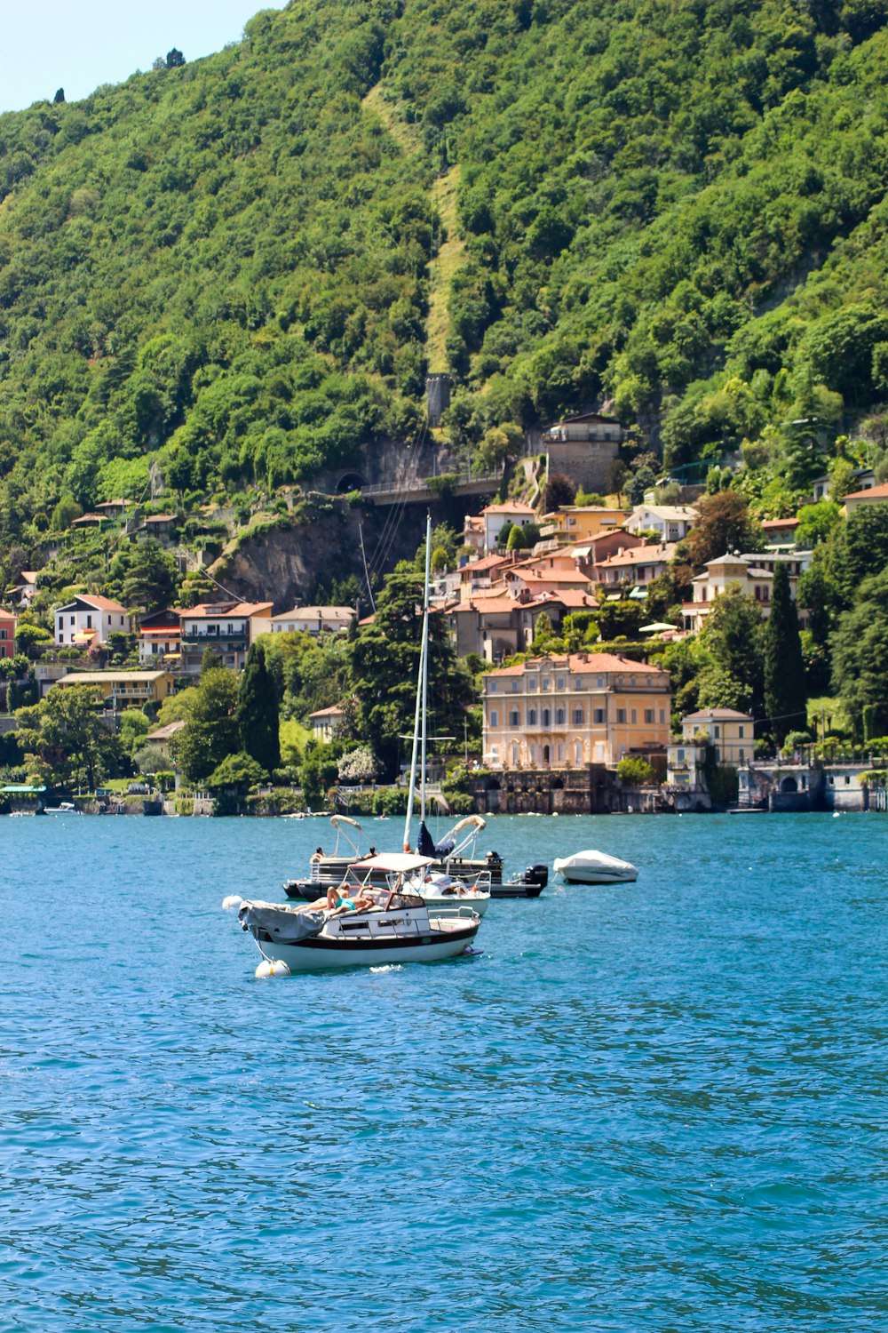 white boat on body of water near city buildings during daytime