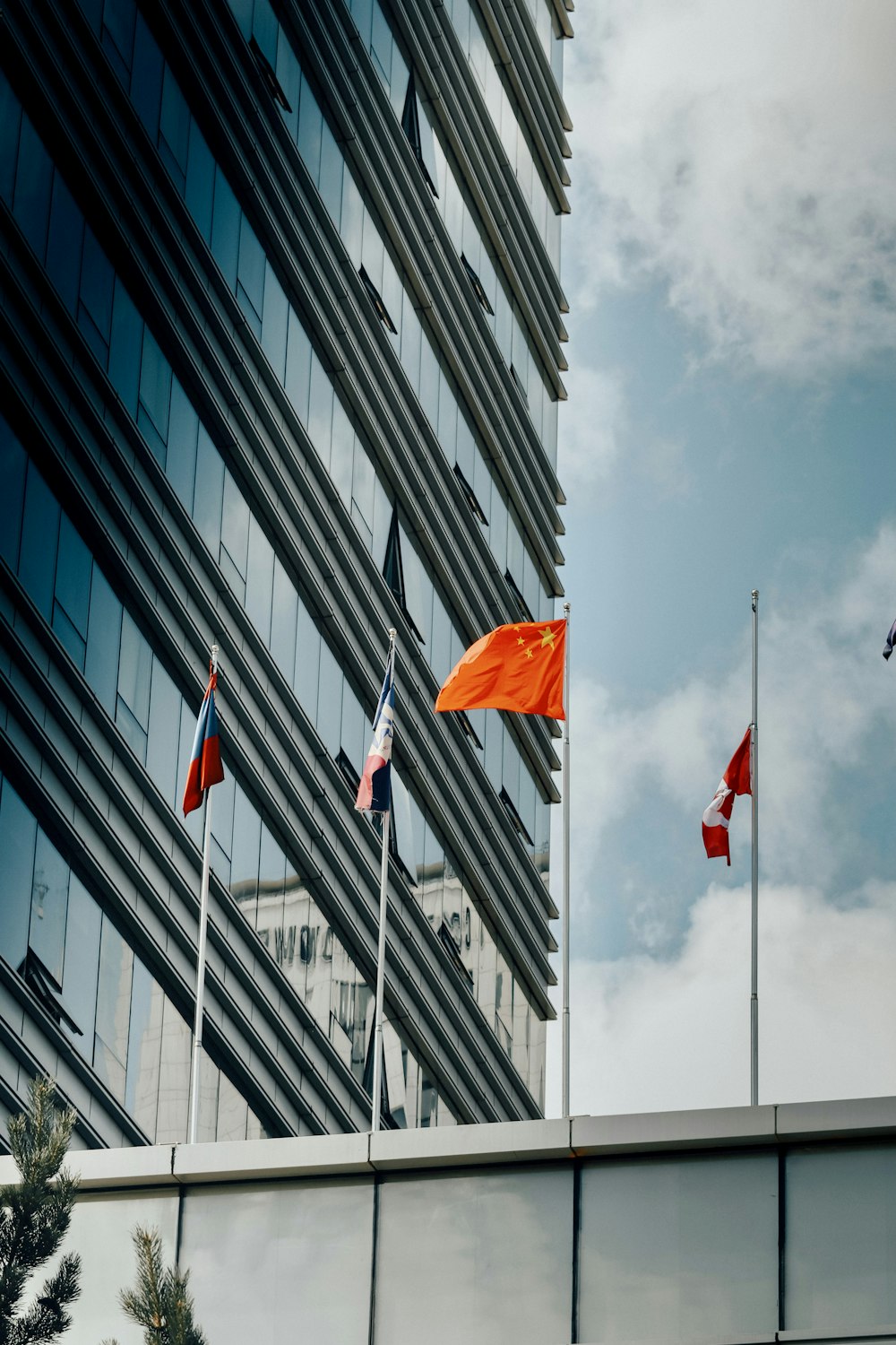 red flags on pole near building during daytime