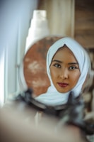 woman in white hijab taking selfie