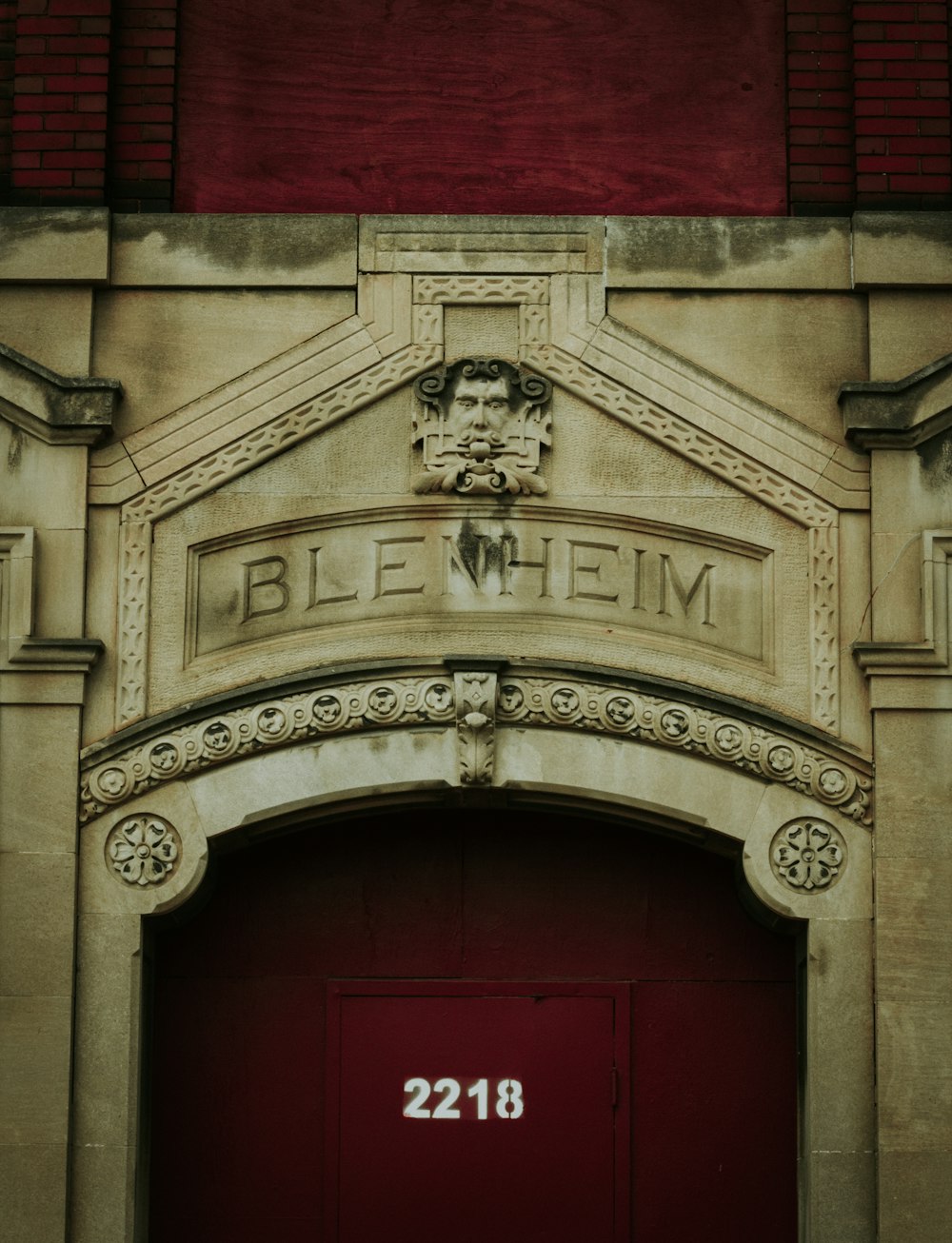 Puerta de madera roja con pared de hormigón gris