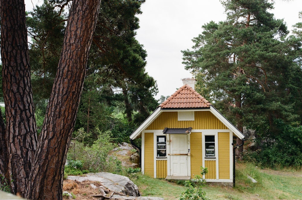 white and brown wooden house near green trees under white sky during daytime