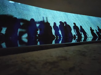 Abstract shadows cast by dancers on a textured wall.