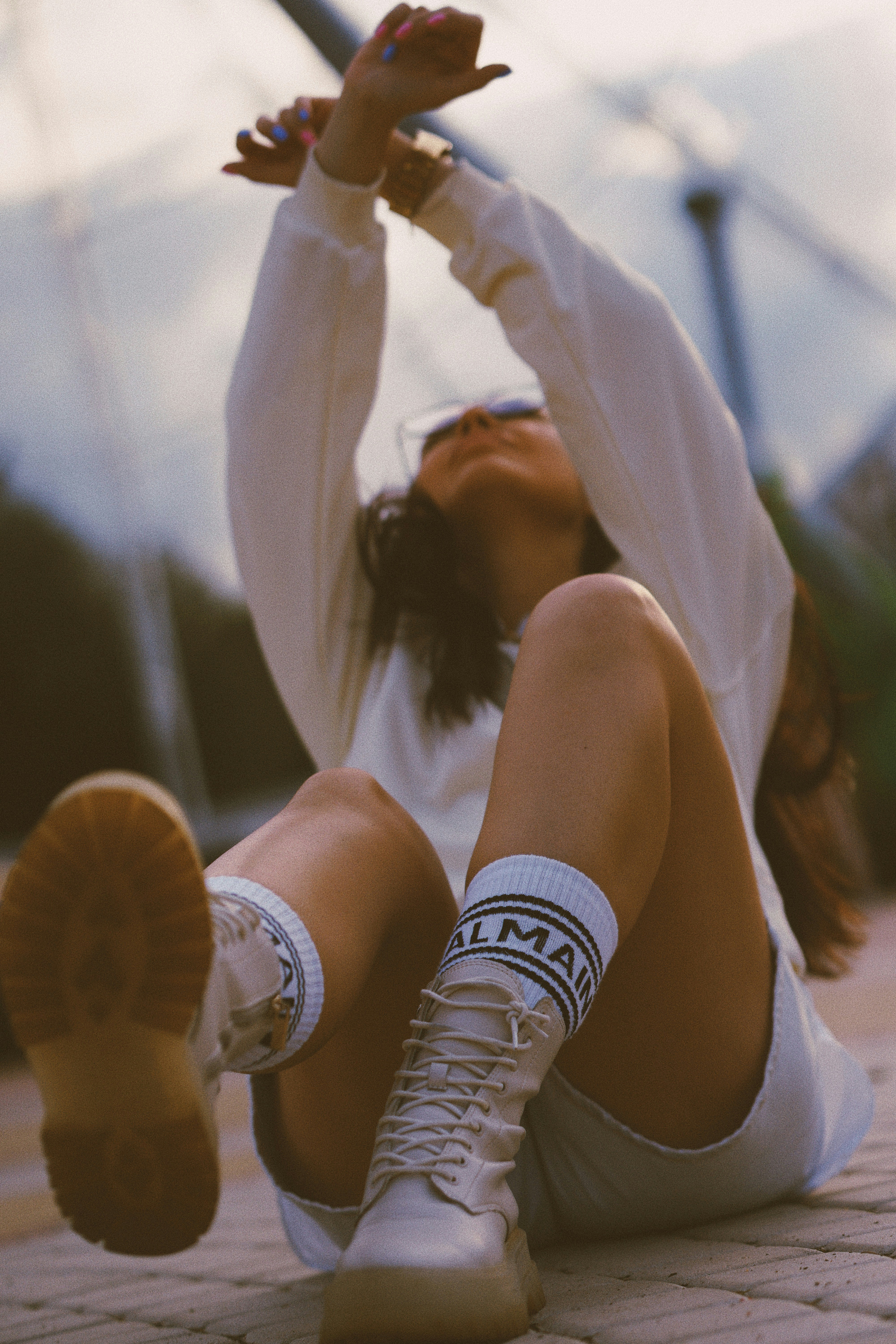 Donna in canotta bianca e pantaloncini bianchi con Converse All Star High bianche e nere