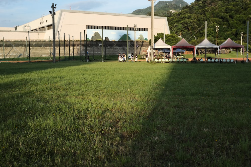 people walking on green grass field near white concrete building during daytime