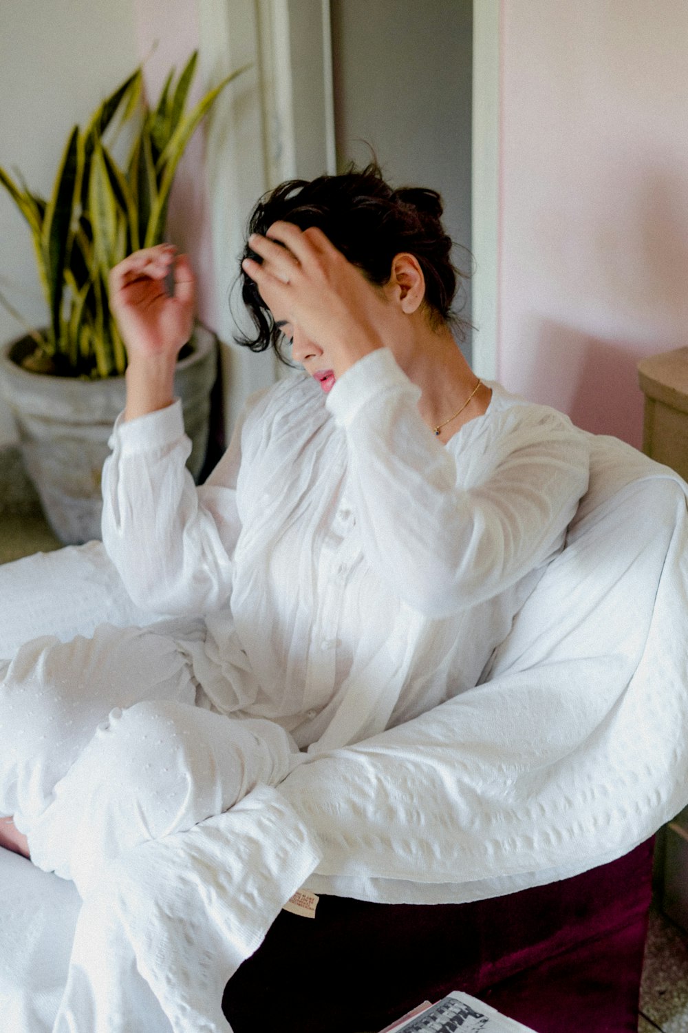 woman in white long sleeve shirt sitting on white bed