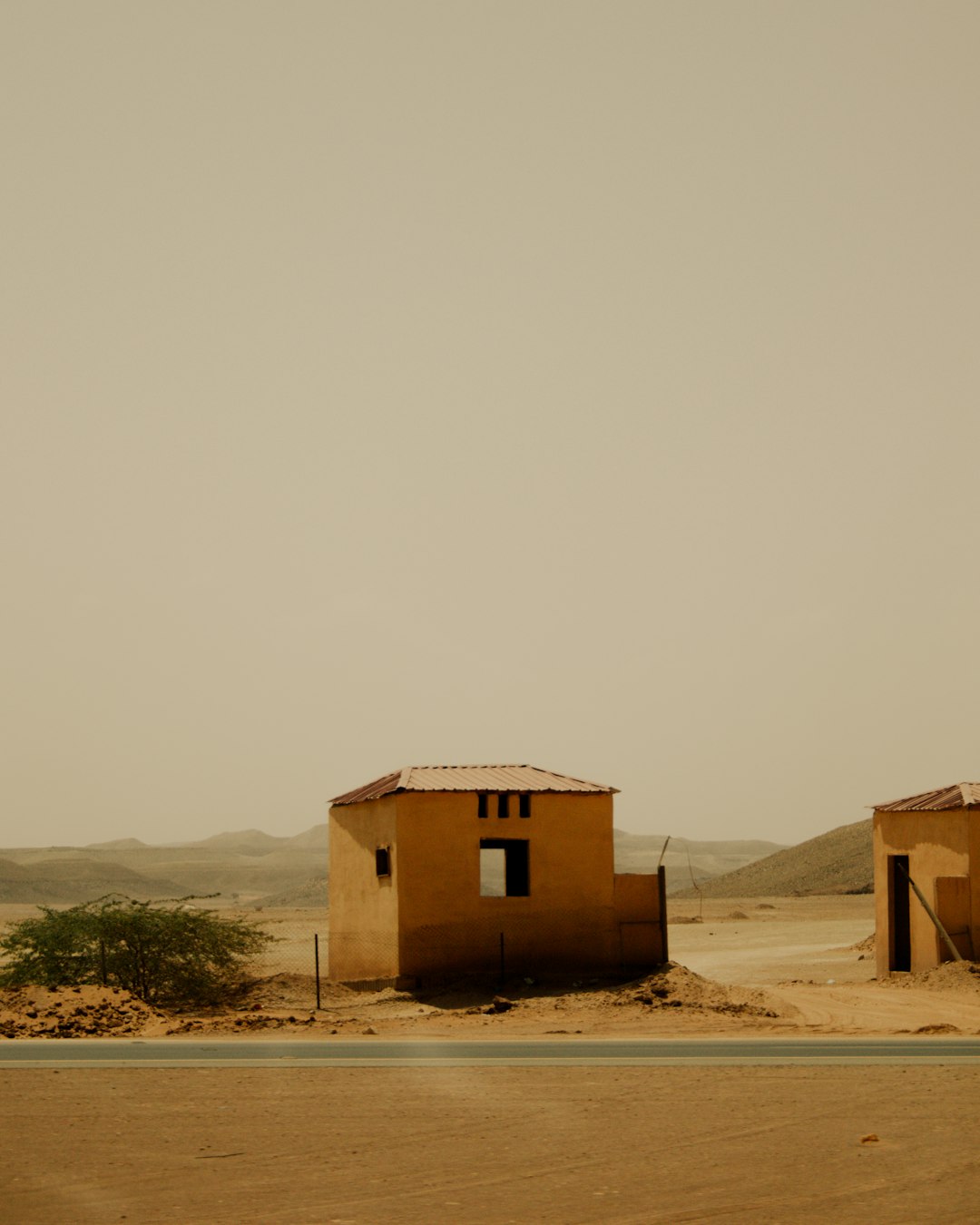 brown wooden house on brown sand during daytime