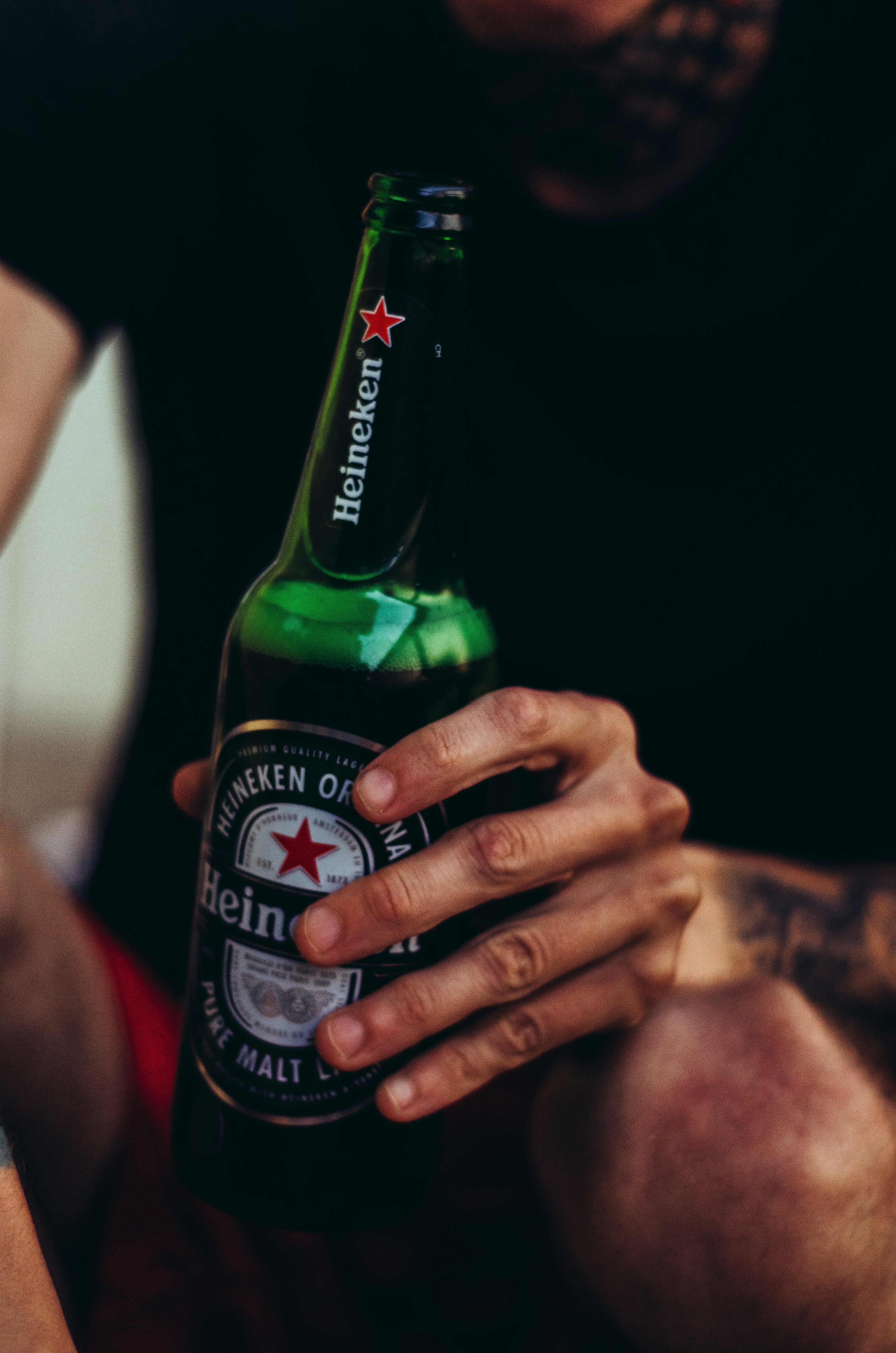 person holding green glass bottle