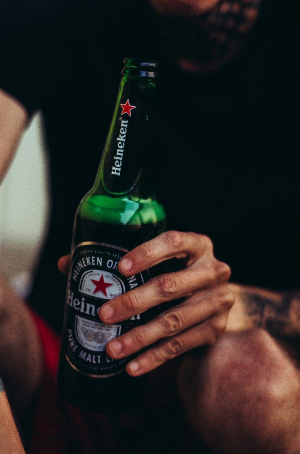 person holding green glass bottle