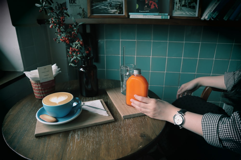 person holding orange plastic bottle