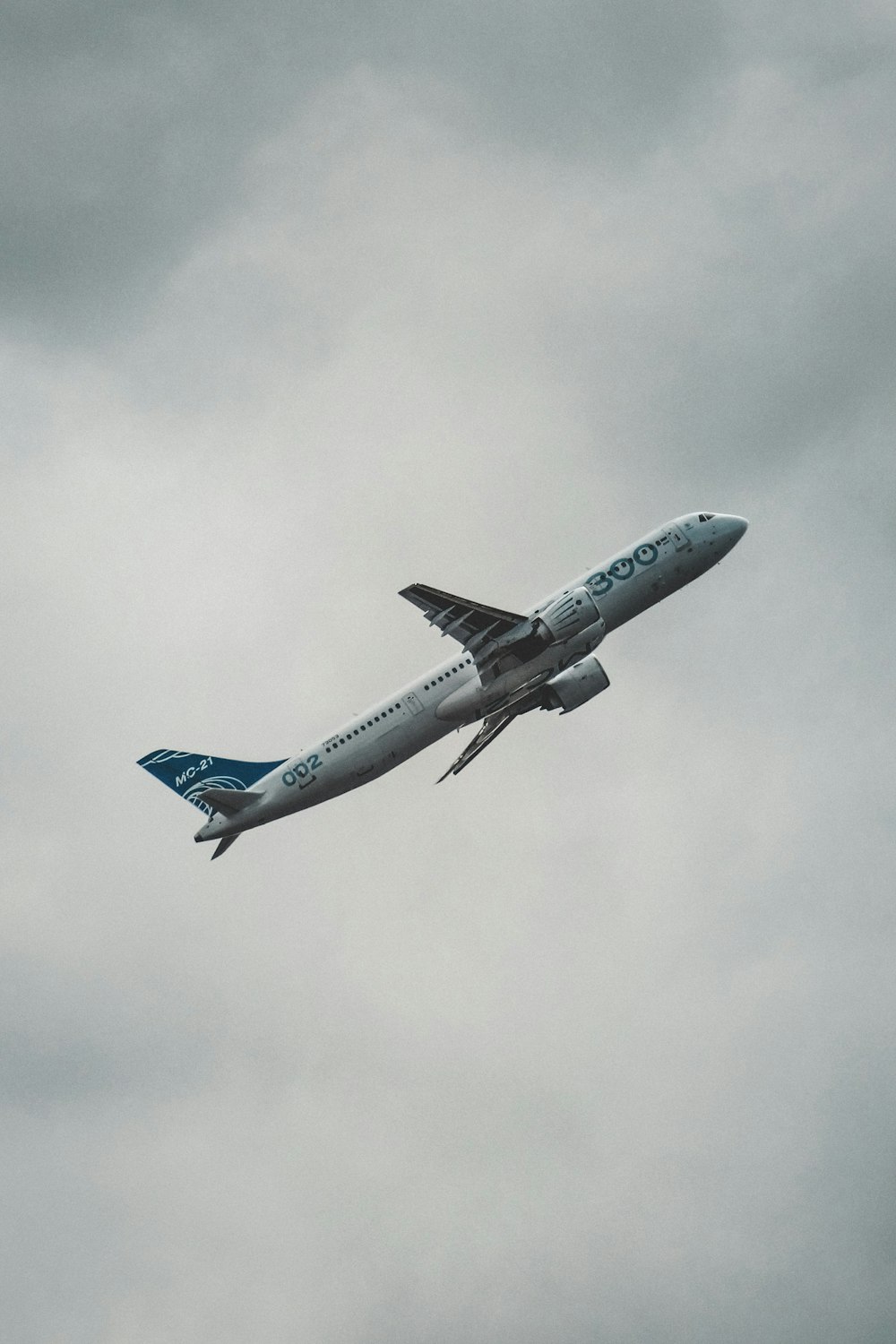 white and blue airplane under white clouds during daytime