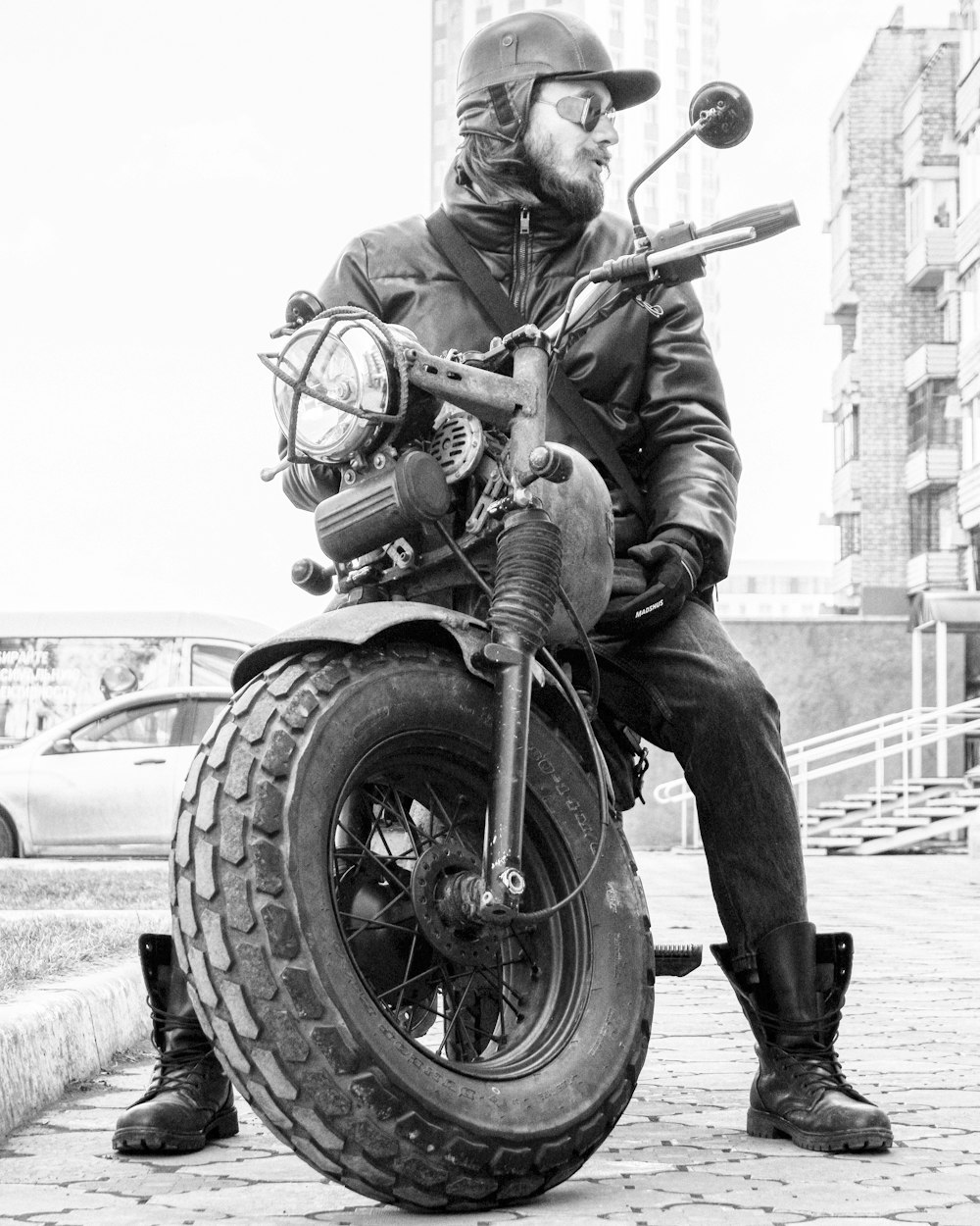 Foto en escala de grises de un hombre montando una motocicleta