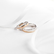 two wedding rings sitting on top of a white cloth
