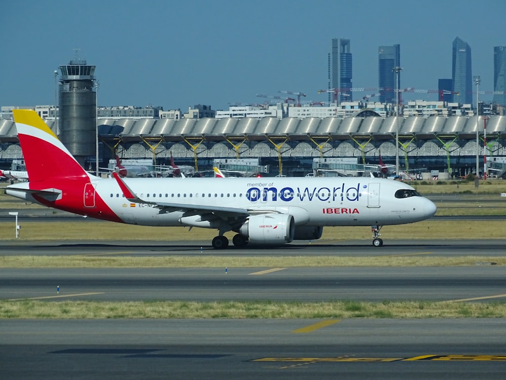 昼間の空港の白と赤の旅客機