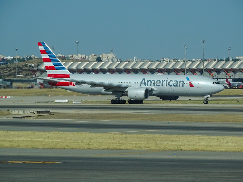 white and red passenger plane on airport during daytime