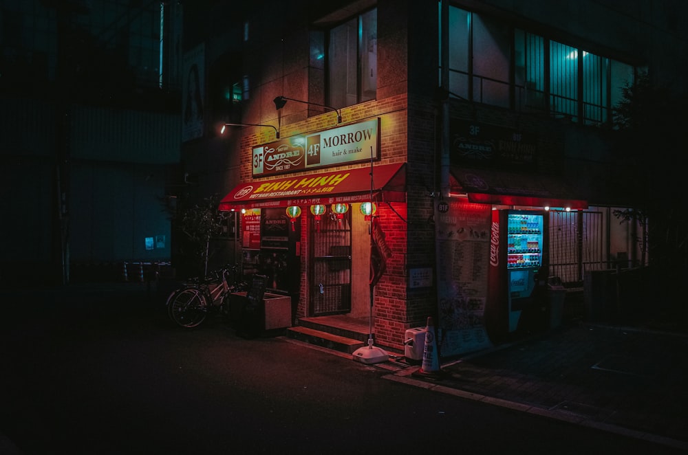 black bicycle parked beside store during night time