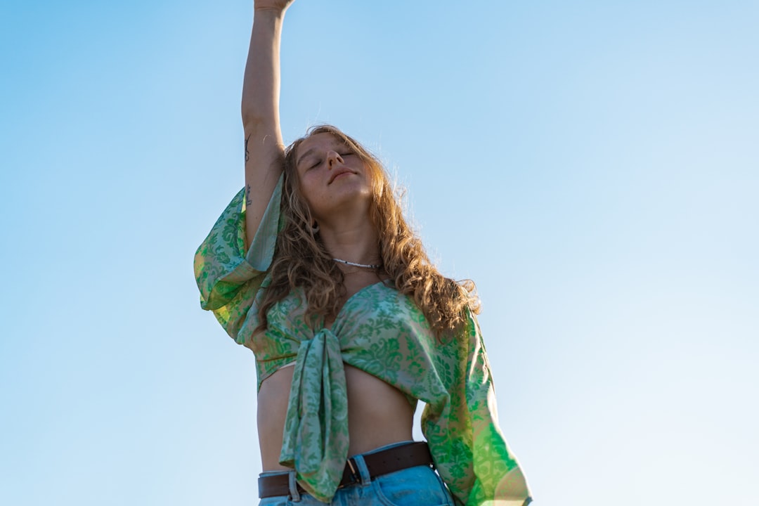 woman in green and black scarf raising her hands