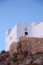 white concrete building on brown rocky hill during daytime