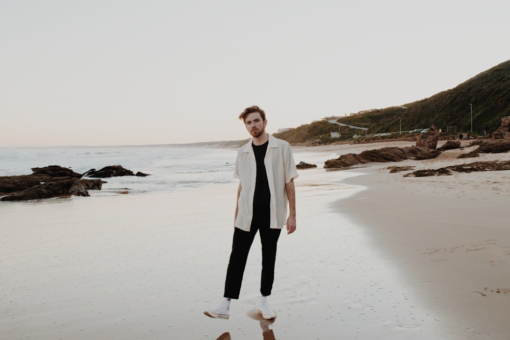 femme en blazer blanc debout sur la plage pendant la journée