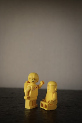 two gold human figures on black table