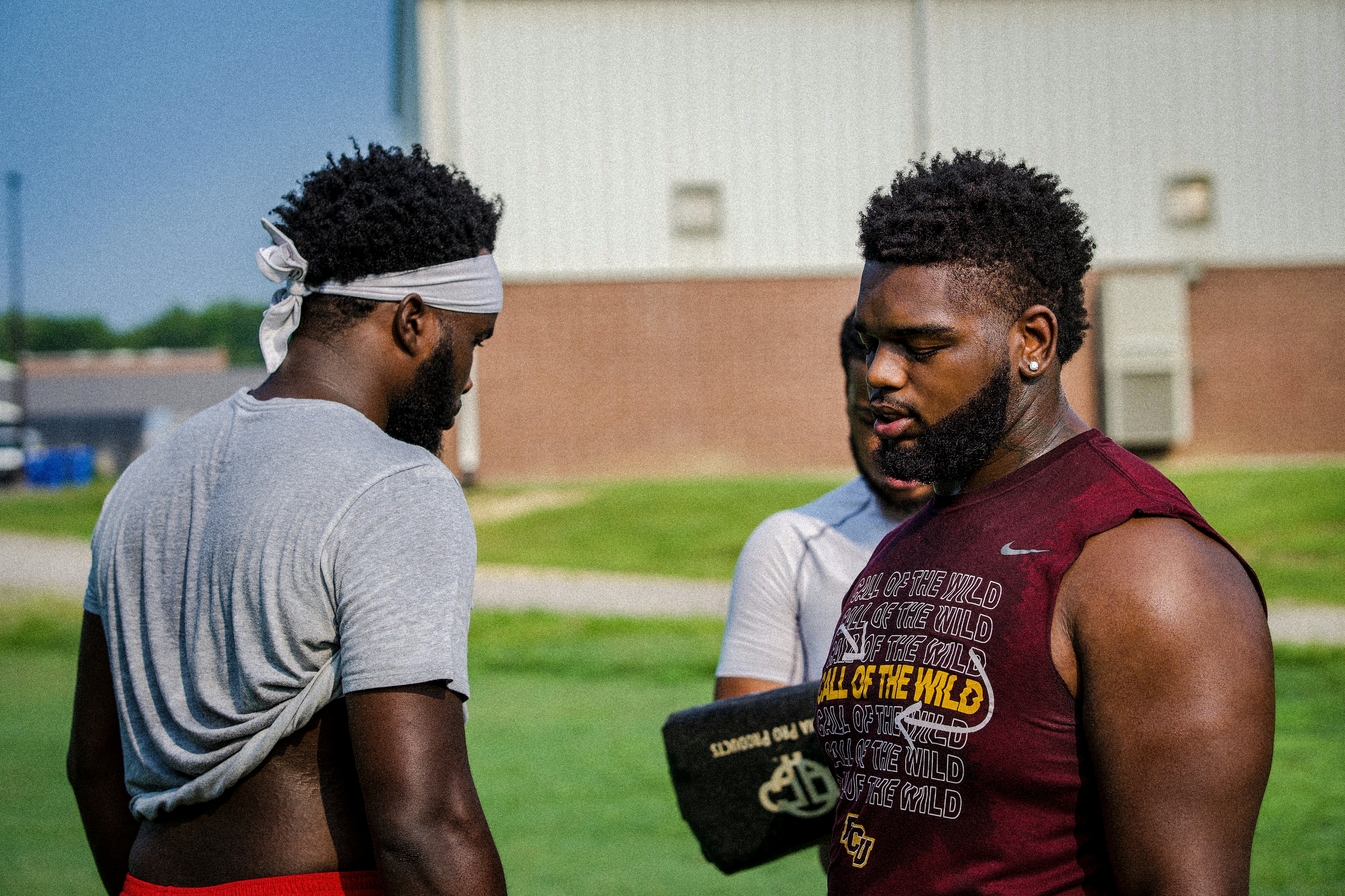 man in gray crew neck t-shirt standing beside man in red tank top