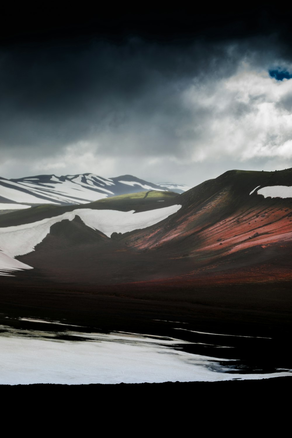 montagnes brunes et blanches sous ciel gris