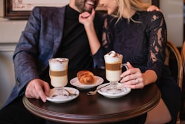 A happy couple meeting for the first time, smiling in a cozy café setting arranged by Elite Matchmaking.