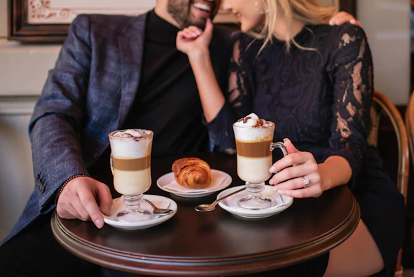 A couple sharing a warm drink together at a wooden table