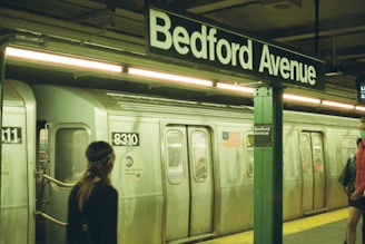 woman in black jacket standing beside train