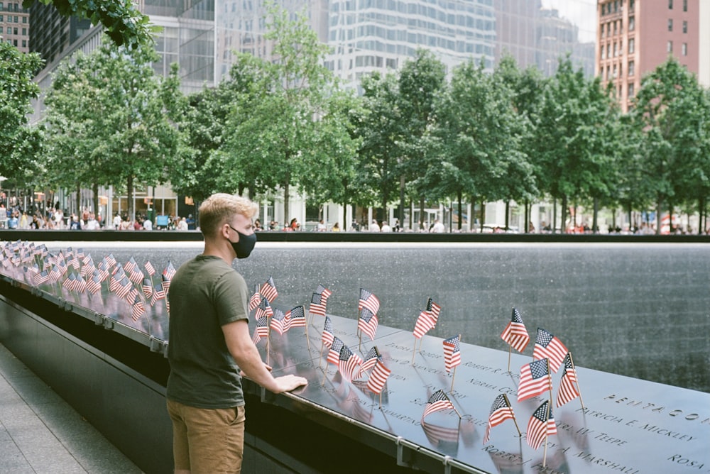 a man standing next to a wall with american flags on it