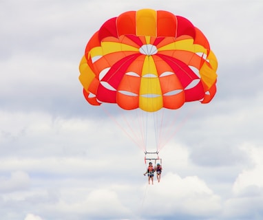 2 person riding parachute during daytime