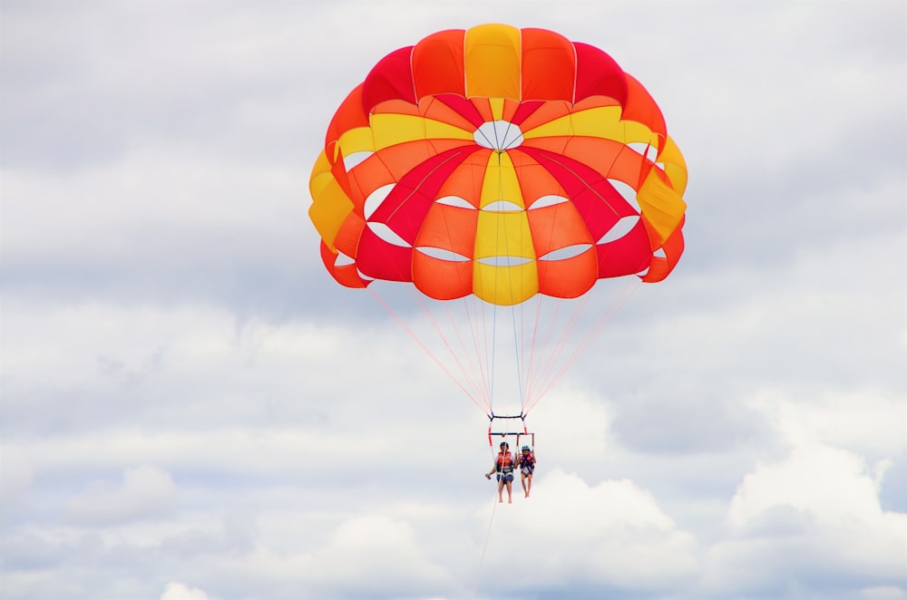 2 person riding parachute during daytime