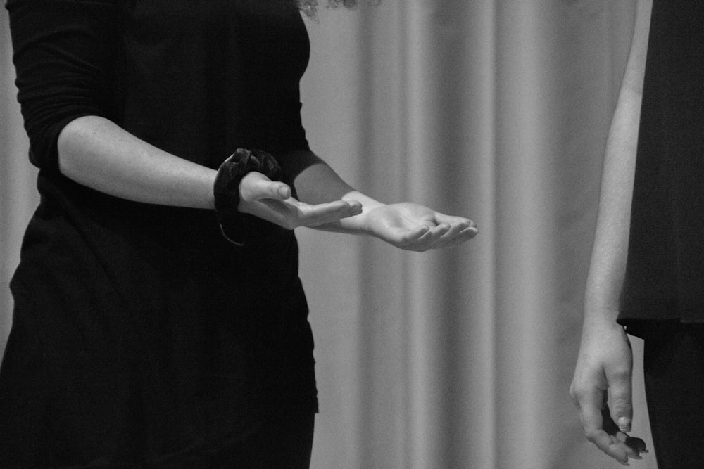 person in black dress standing on white curtain