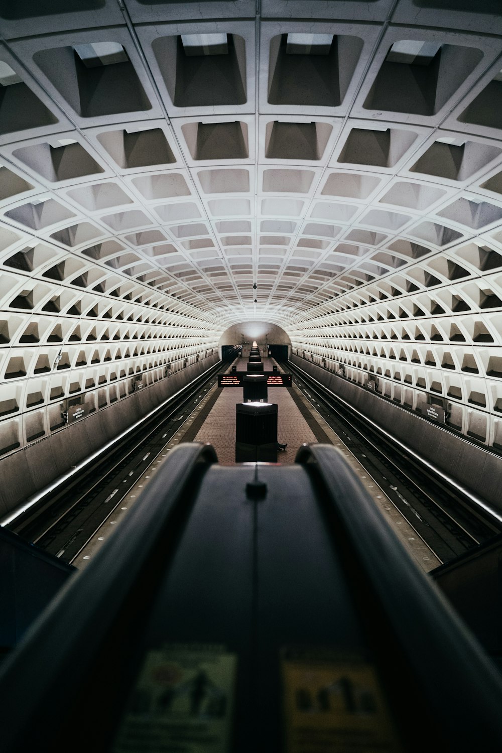 person walking on black escalator