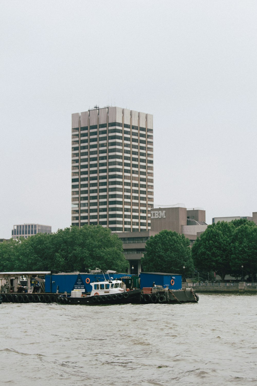 people riding boat on river near high rise building during daytime