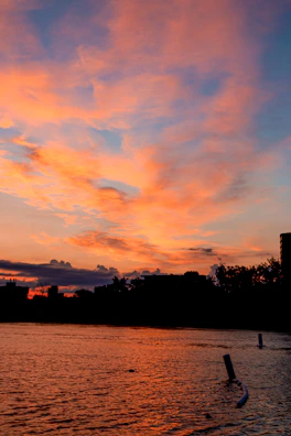 A vibrant sunset painting the sky orange and pink over the winding river channels.
