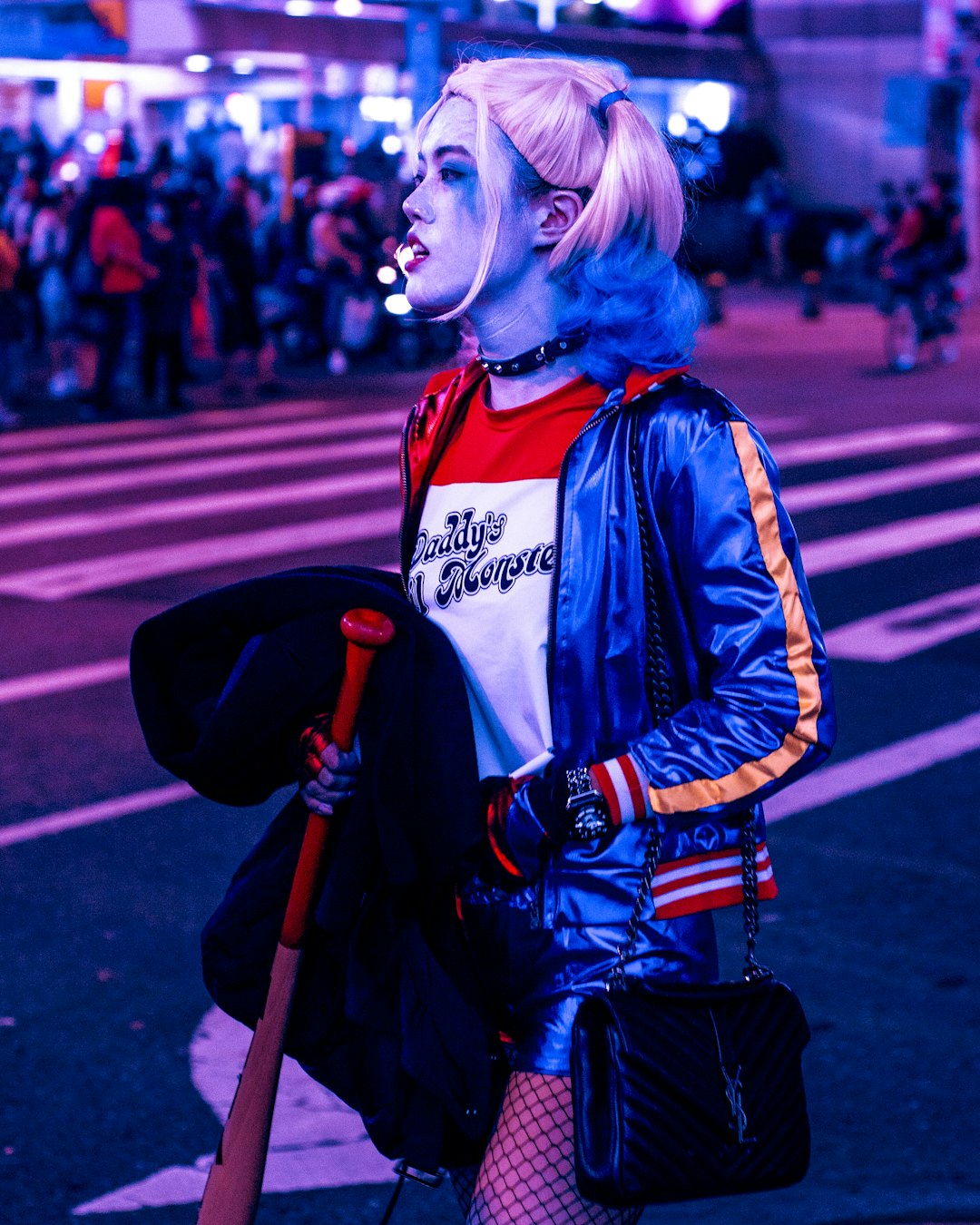 woman in blue and black jacket holding brown stick