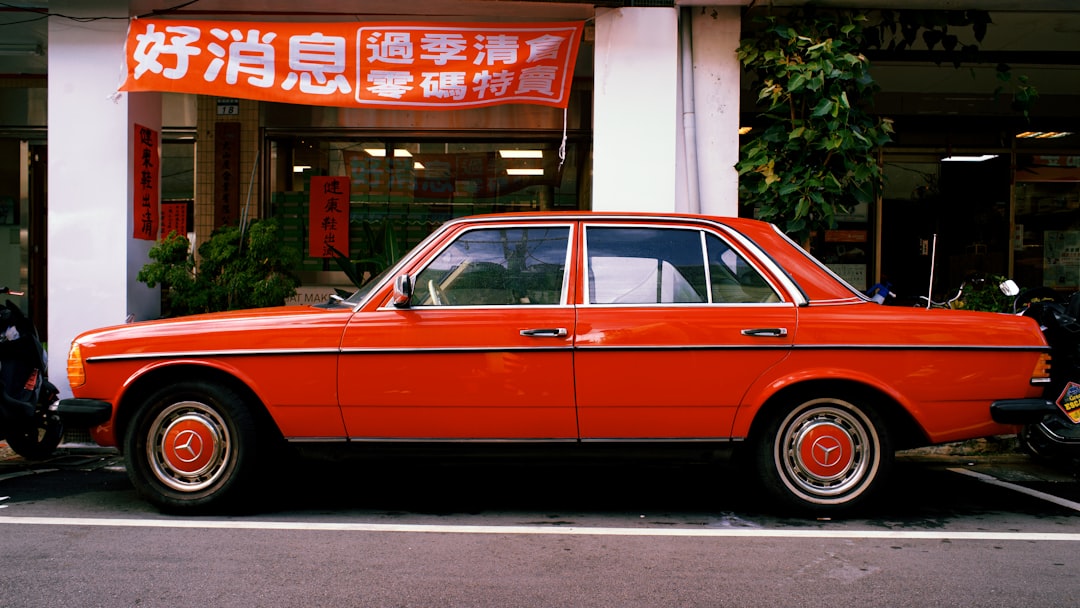 orange sedan parked beside store