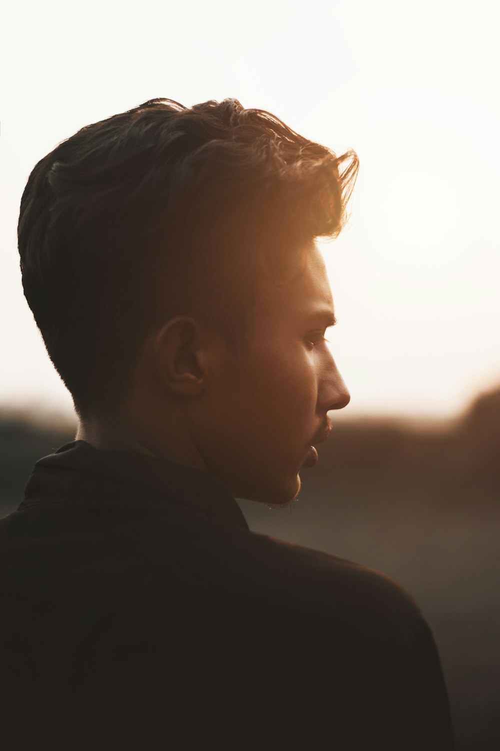 boy in black shirt looking at the sun