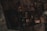 A collection of vintage and antique objects is displayed on a dimly lit stone mantel. There are metallic vases, lamps, and what appears to be an old toy car, with intricate designs and muted colors. The lighting is low, creating a mysterious and nostalgic atmosphere.