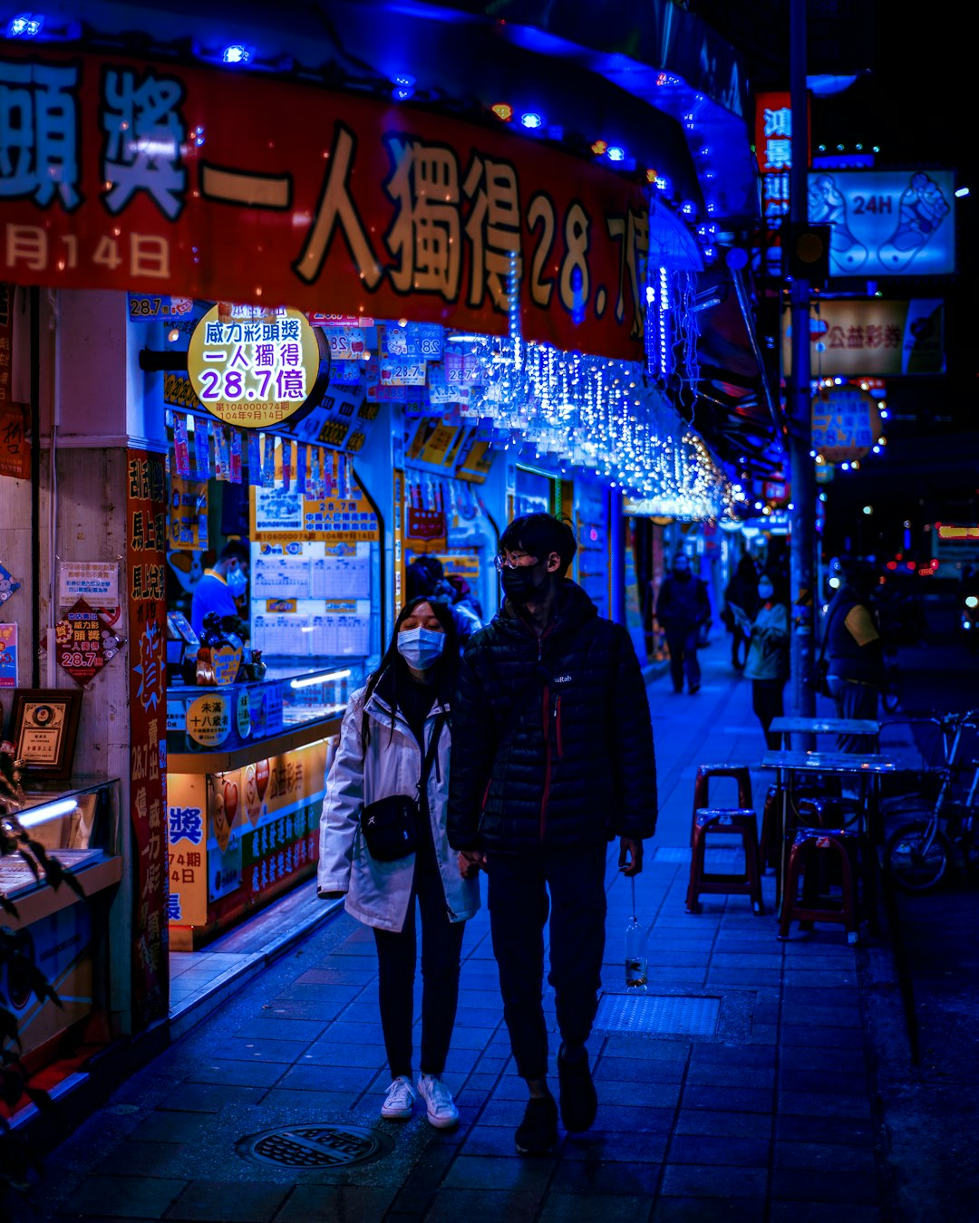 man in black jacket standing beside woman in blue jacket