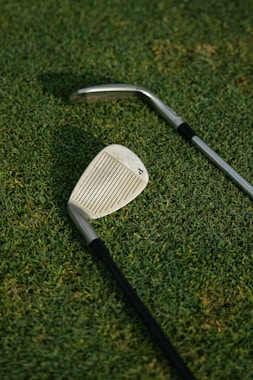 grey and black golf club on green grass