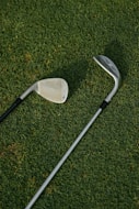 white and black golf club on green grass