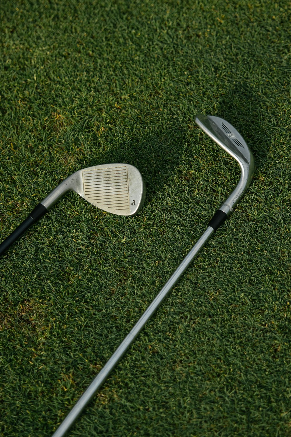 white and black golf club on green grass