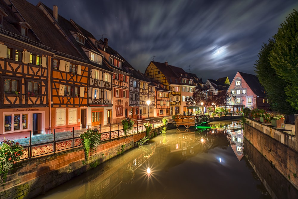 brown and white concrete building beside river during night time