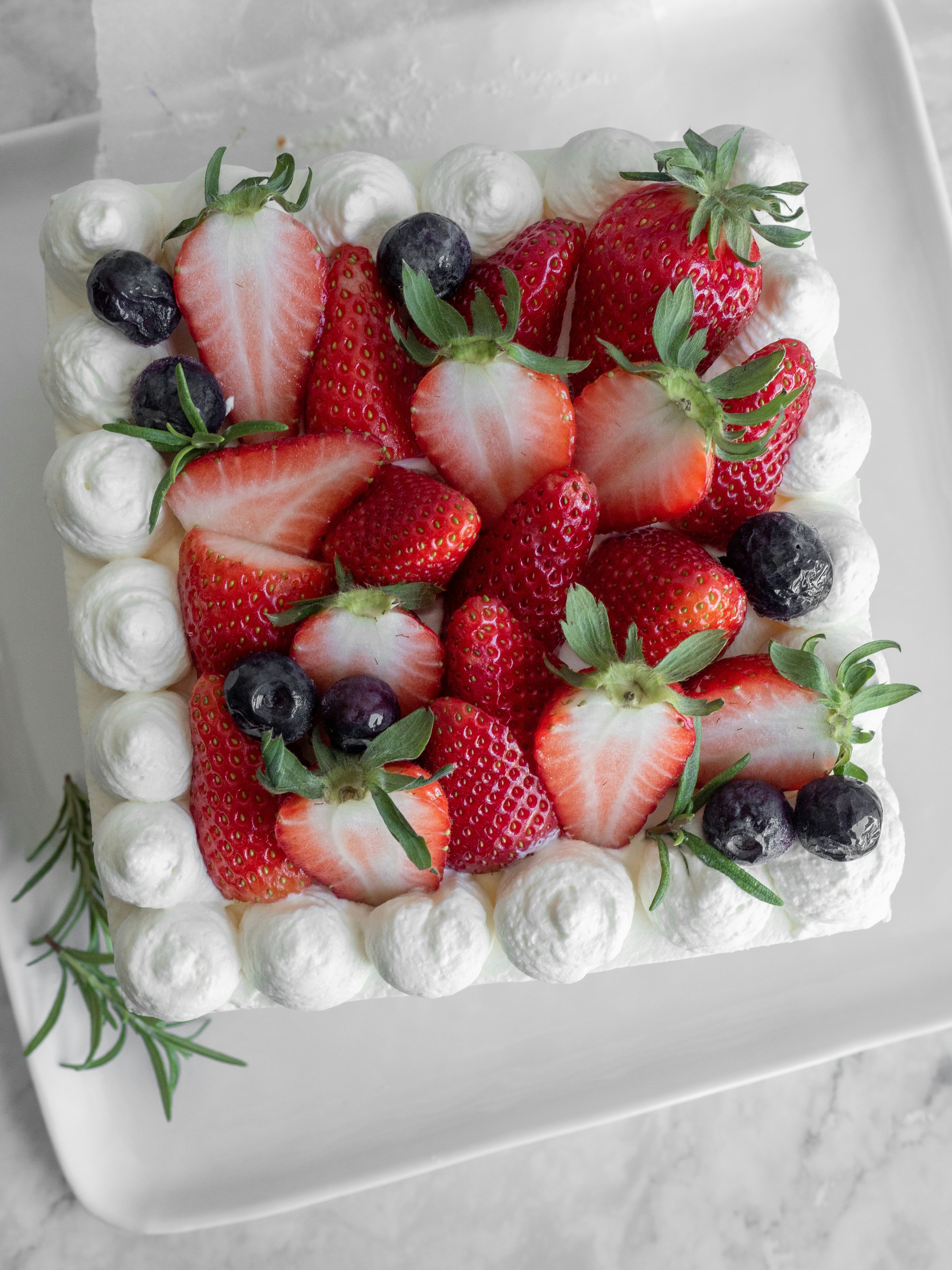 strawberries and blueberries on white ceramic tray
