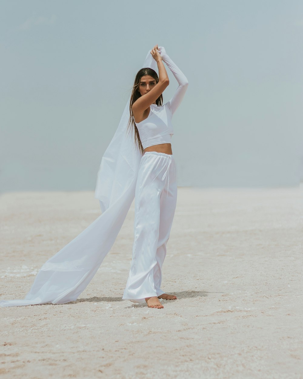 woman in white sleeveless dress standing on white sand during daytime