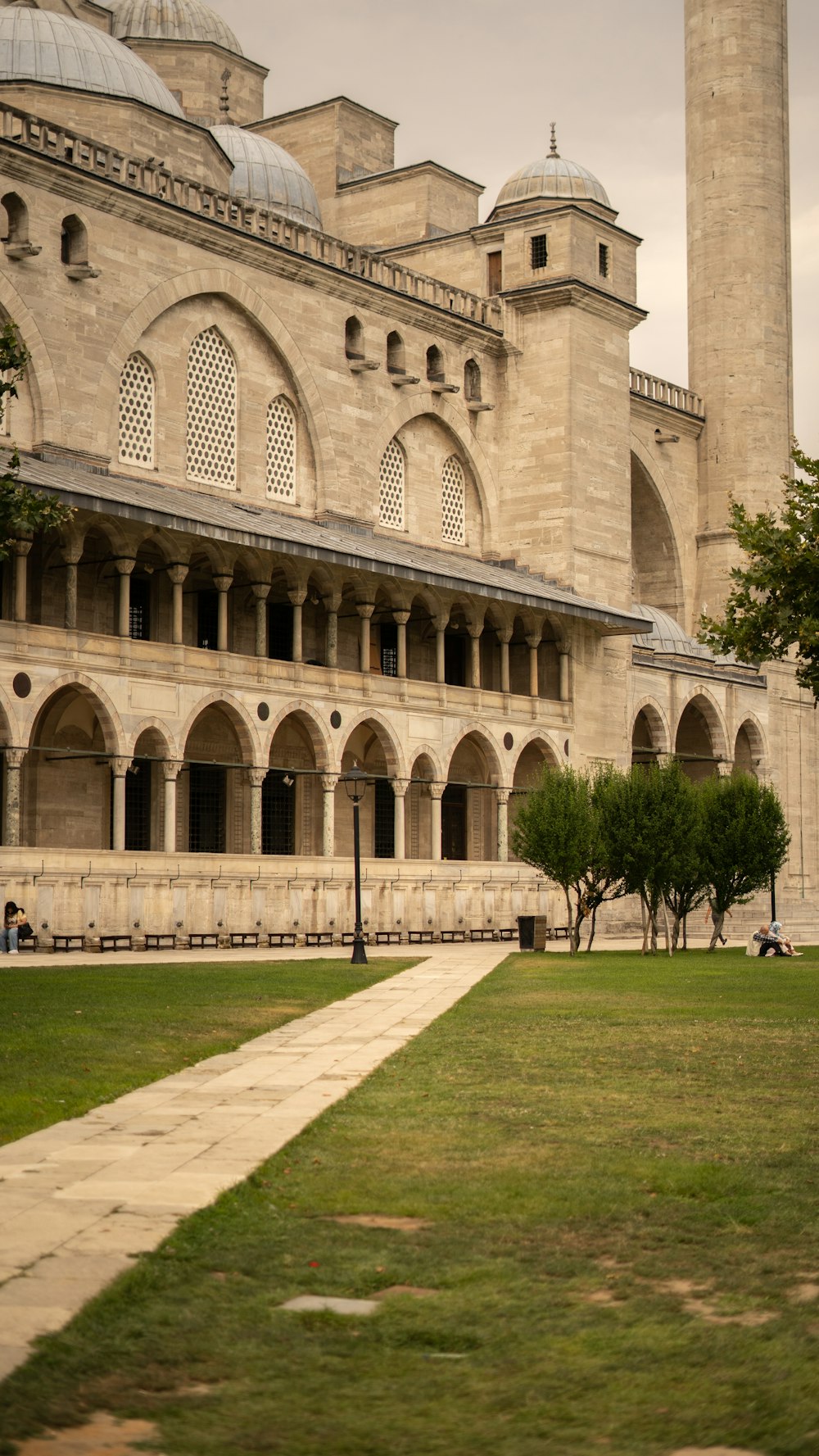 people walking on green grass field near brown concrete building during daytime