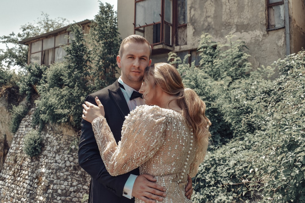 man in black suit jacket hugging woman in brown floral dress